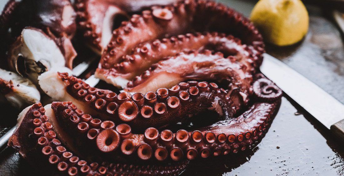 un pulpo cocido sobre una tabla de pizarra