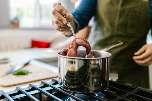 un cocinero respetando el tiempo de cocción del pulpo en una cocina