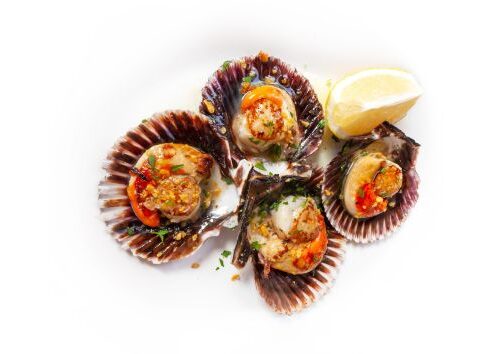 un plato de zamburiñas a la plancha con limón