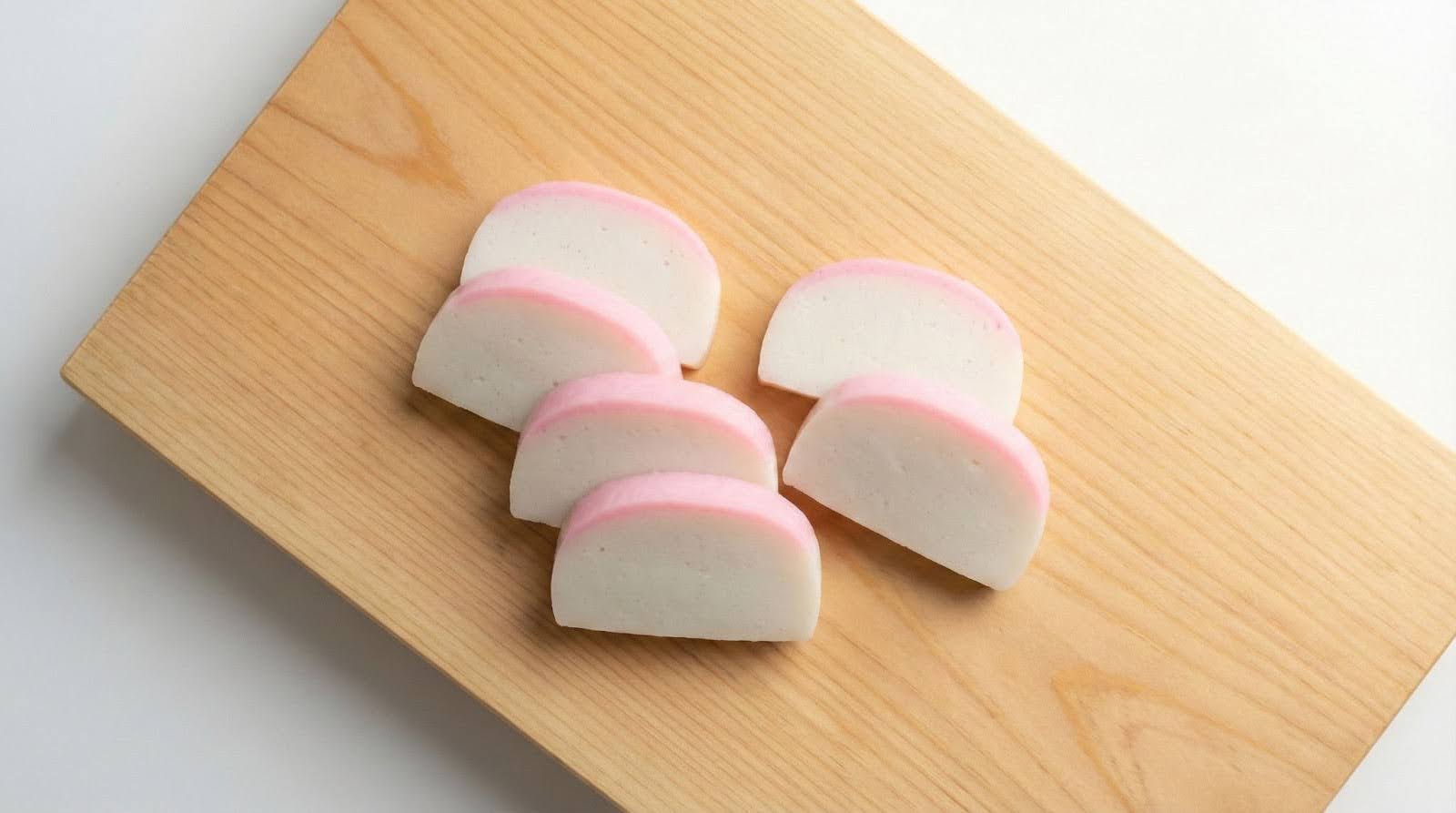 Kamaboko japonés cortado en rodajas sobre tablilla de madera
